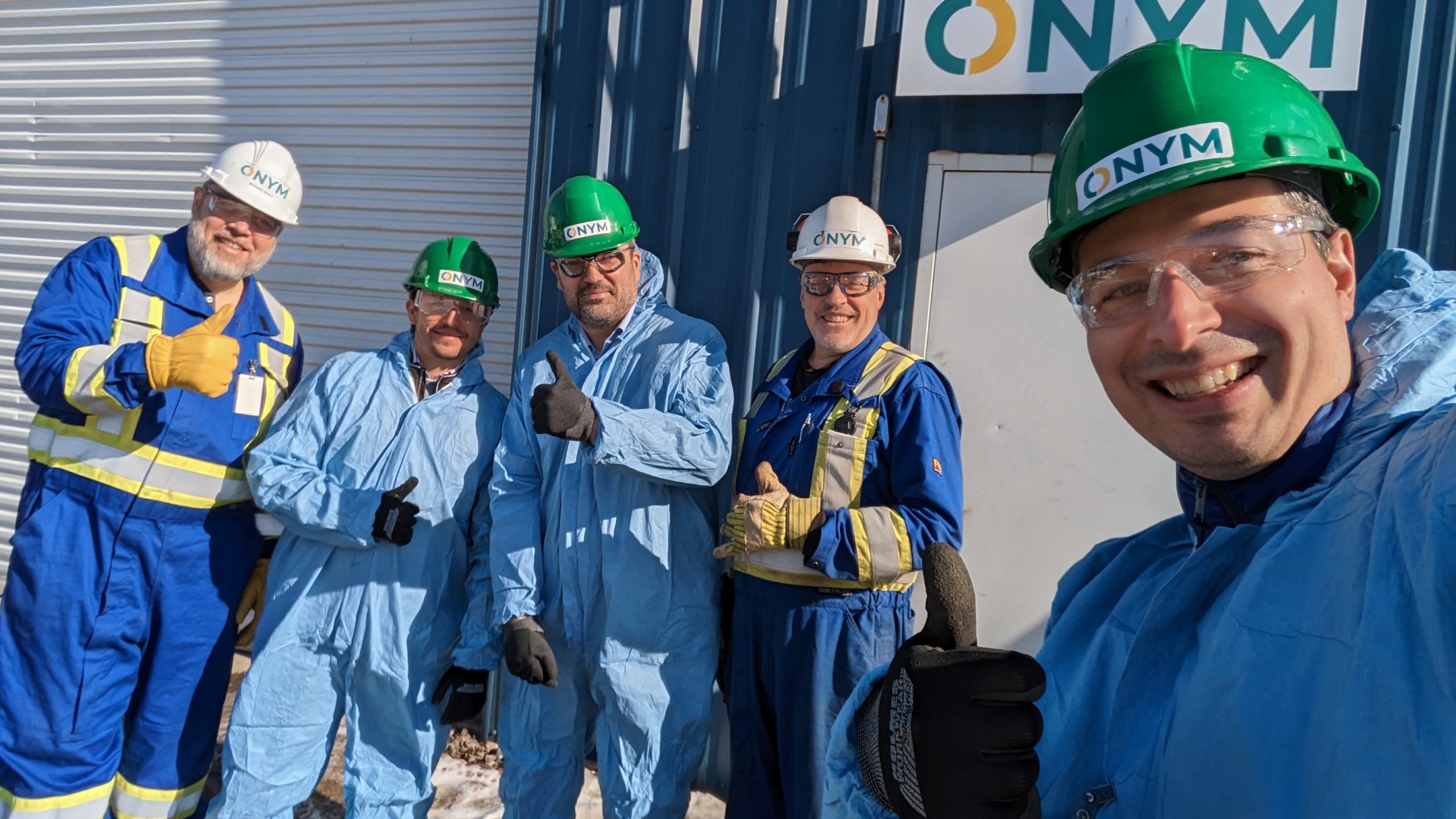 Bioénergies – Groupe Onym reçoit un soutien de 10000$ du Fonds C Cinq hommes pose en habits de protections devant une usine de bioénergies et de bioproduits.
